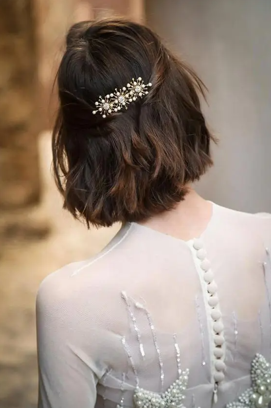 a long bob with wavy hair, styled as a half updo, with a beautiful rhinestone hair barrette is wow