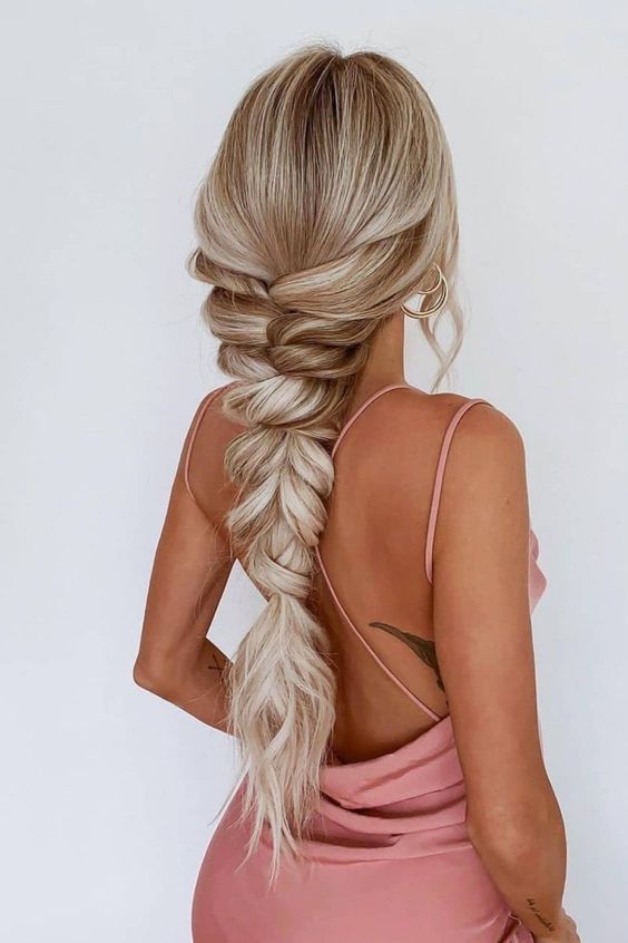 a loose and thick braidwith textured hair is a cool and chic idea for a wedding