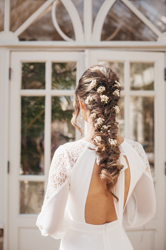 a loose twisted braid with white baby’s breath blooms is a chic and cool idea for a wedding
