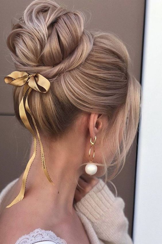 a lovely and glam top knot with twists and a volume on top plus face-framing hair is a cool and chic idea