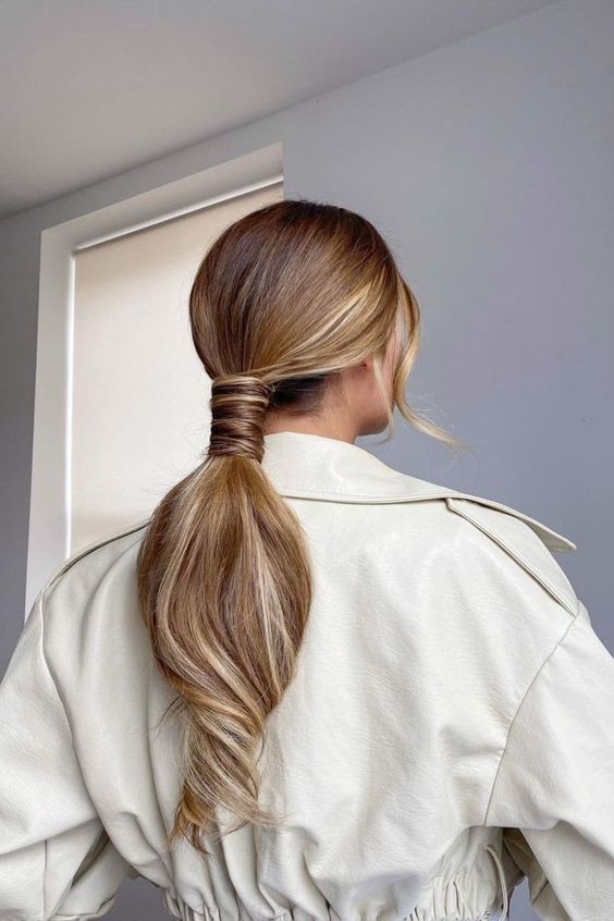 A lovely low ponytail with a sleek top, a volumetric ponytail and face framing hair is a cool idea for a modern bride