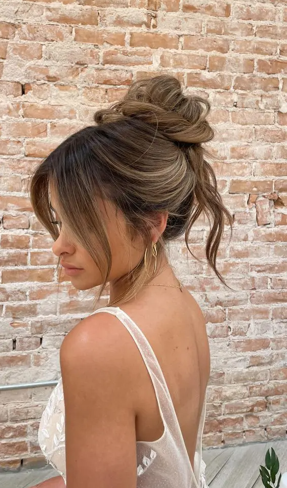 a lovely messy twisted top knot with some hair down and face-framing bangs is a cool idea for medium hair