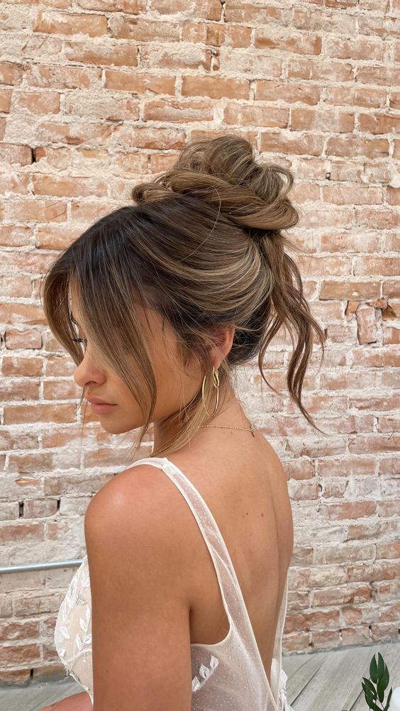 A lovely messy twisted top knot with some hair down and face framing bangs is a cool idea for medium hair
