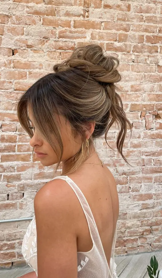 A lovely messy twisted top knot with some hair down and face framing bangs is a cool idea for medium hair