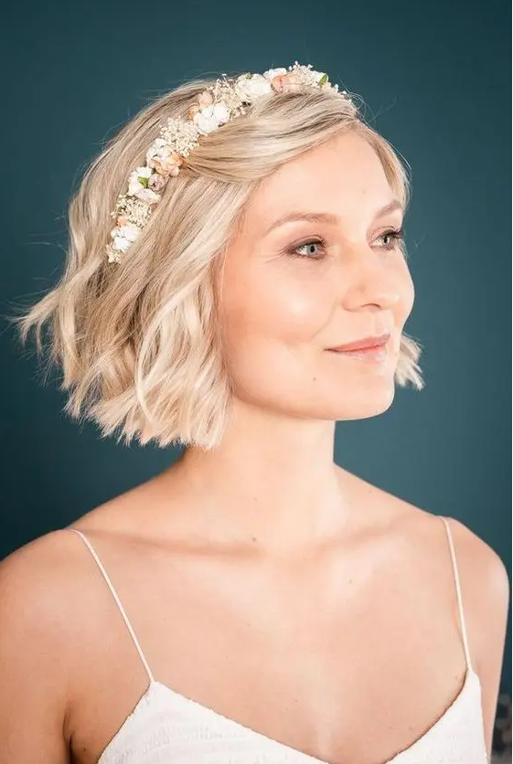 a lovely soft blonde wavy bob with a fresh flower headband is a cool and lovely solution for a wedding