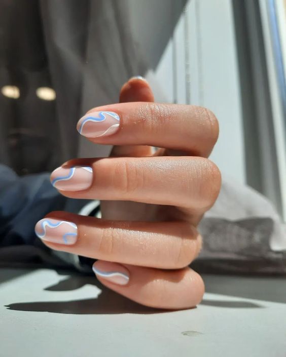 a lovely spring nail art, swirl nails done in blush, pastel blue and white is a cool idea to refresh your look for the season