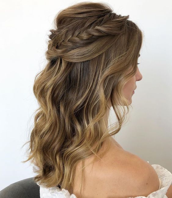 a lovely wedding half updo with a bump on top and a braided and twisted halo plus waves down is a cool solution
