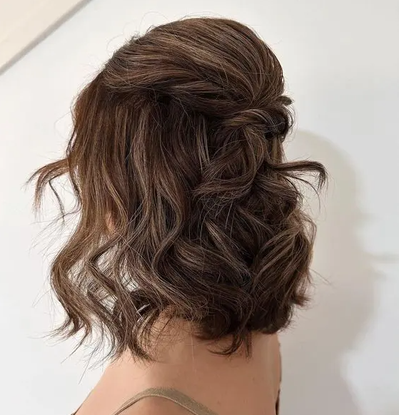 a medium half updo with a bump and twists plus waves down is a stylish and chic idea for many parties