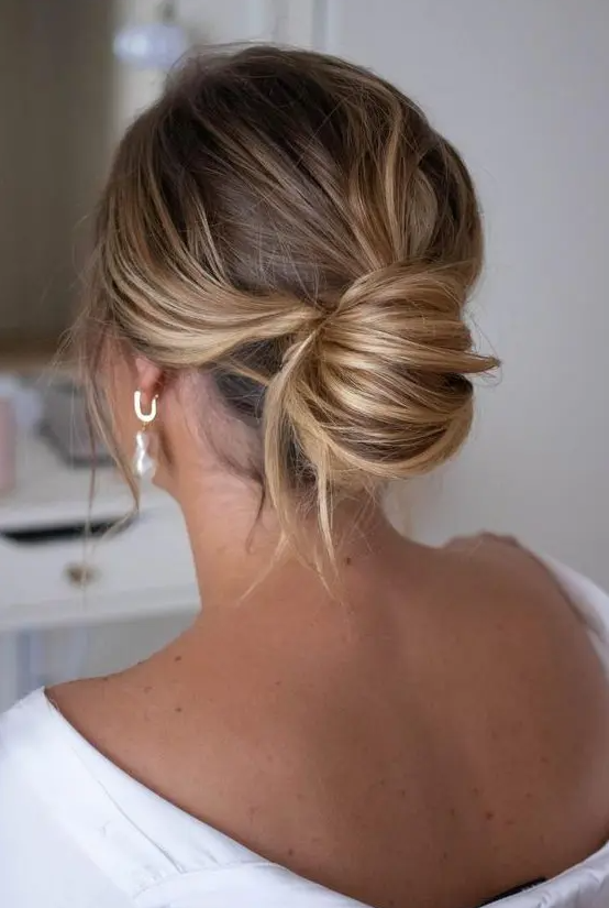 a messy chignon with a messy top and waves down is a chic modern solution without much fuss