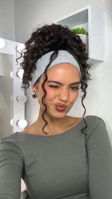 a messy curly high ponytail paired with a stretchy grey headband are all you need for maximal comfort