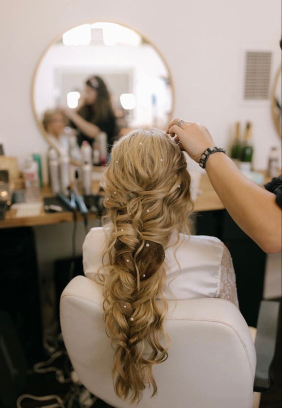 a messy loose braid with pearl hair pins is a nice idea for a more relaxed or boho bridal look