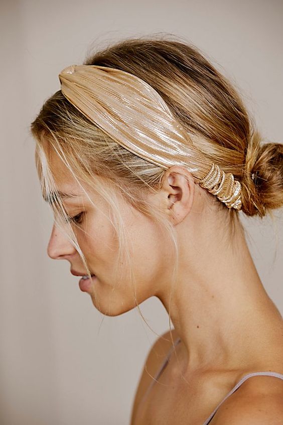 a messy low bun with a messy top and hair down plus a metallic headband are a cool combo for a bold look