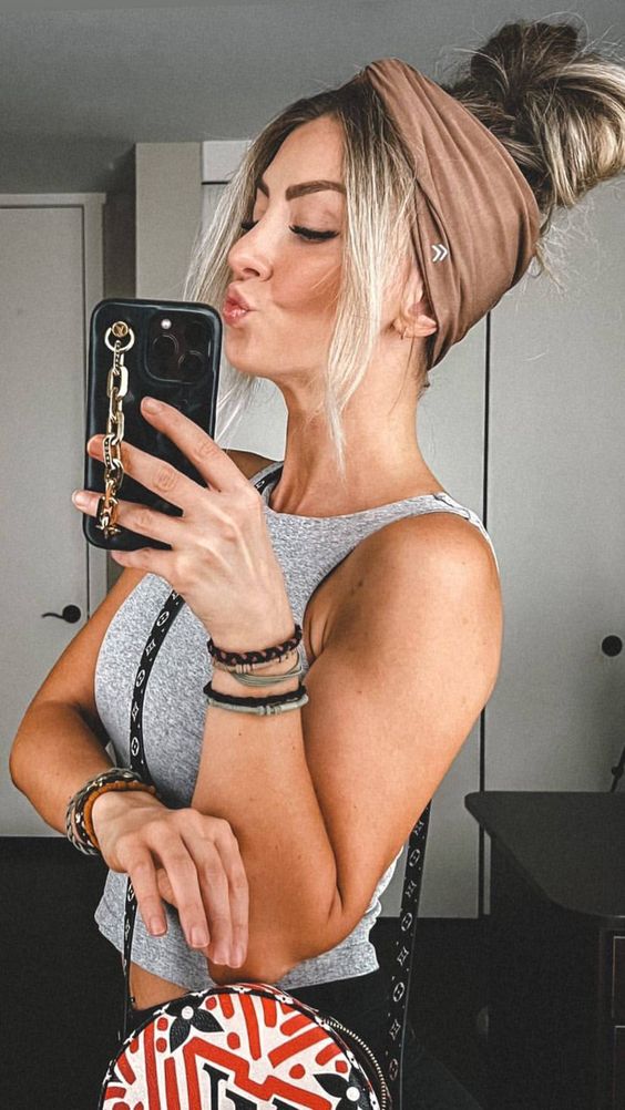 a messy top knot with face-framing hair and a brown stretchy headband are a comfortable solution to keep hair off the face