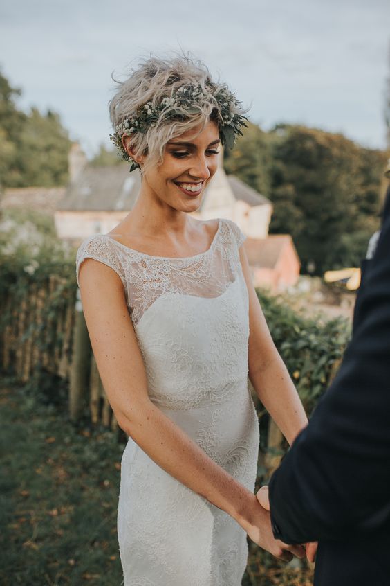 a messy wavy long pixie haircut with a greenery and baby’s breath crown are a lovely combo for a wedding
