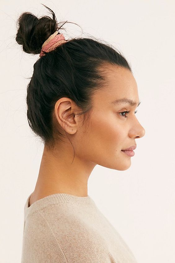 a messy wrapped top knot plus a volumetric top and an elastic are a comfy way to style hair for a workout