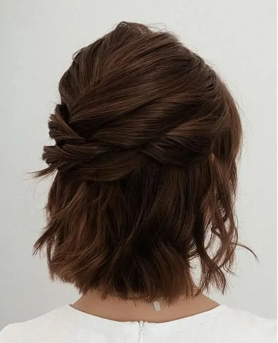 a modern half updo with several twists on top and a bump, with some waves down is a cool idea for a bridesmaid