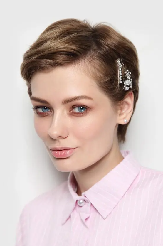 a mousy brown pixie bob accented with pearl hair pins and messy parting plus some volume looks amazing