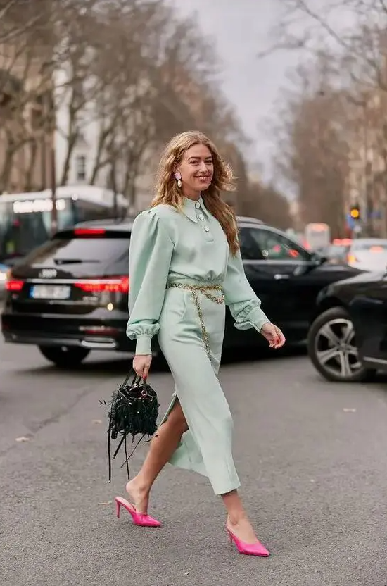 a pretty mint-colored midi shirtdress, hot pink heeled mules, a catchy dark green bag and a gold chain belt