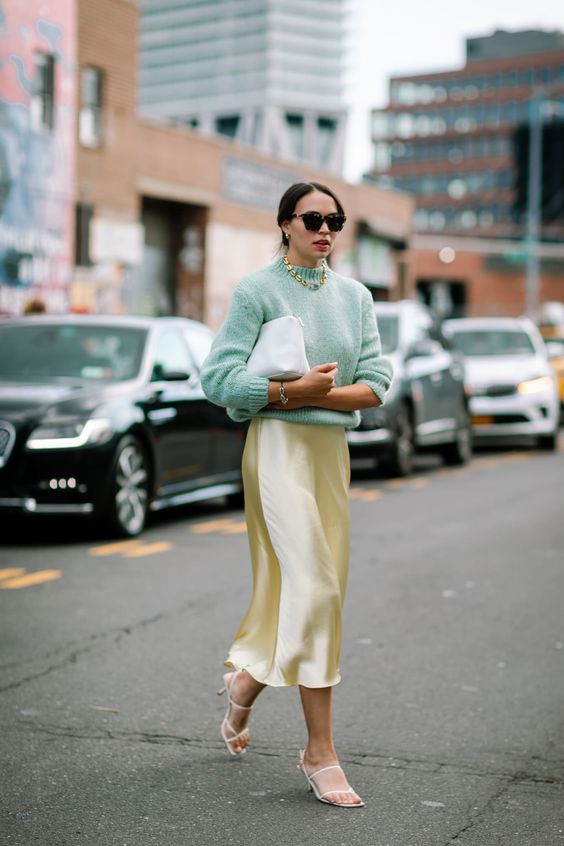 a refined Easter look with a pastel green jumper, a gold slip midi skirt, white strappy shoes and a white bag plus a chain necklace