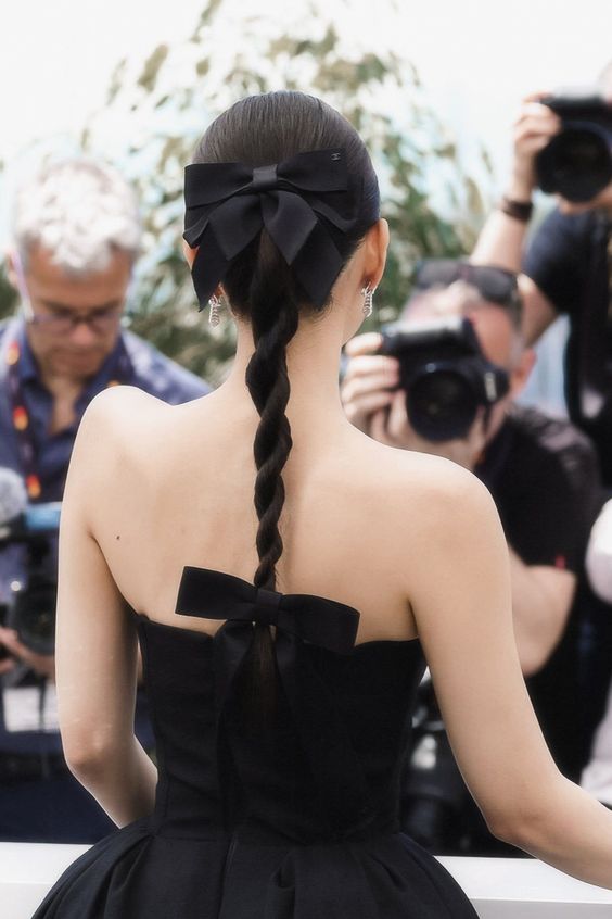 a refined twisted braid accented with two black bows matches the refined black dress, perfect for a special occasion