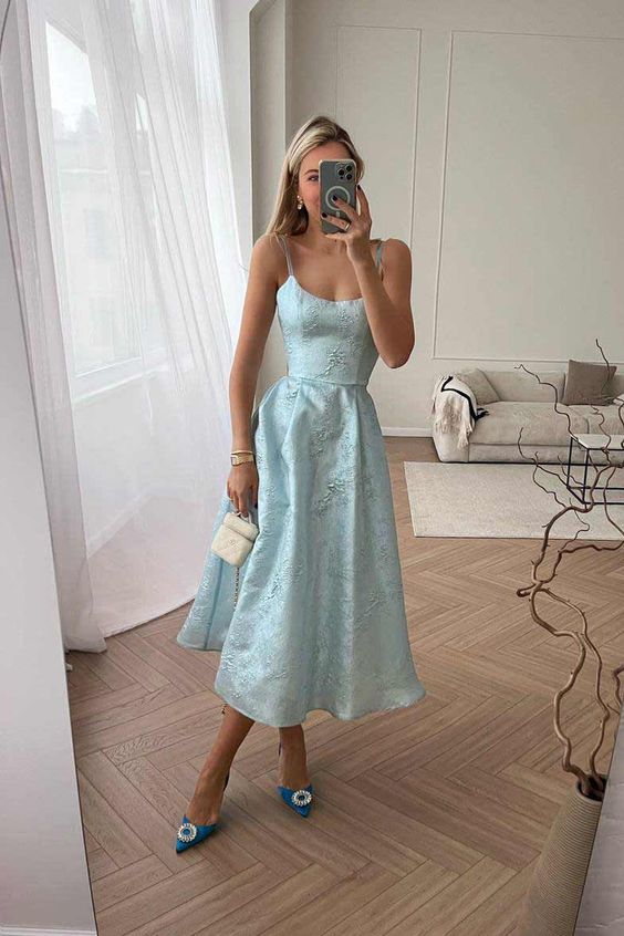 A romantic spring wedding guest look with a pastel blue midi A line embellished dress, blue embellished shoes and a small bag