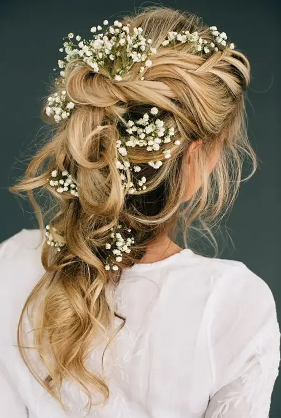 a romantic tousled bridal braid adorned with baby's breath looks ethereal and will be perfect for a boho bride