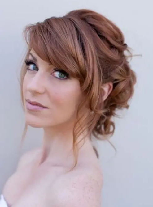 a romantic wavy updo with a bump and side bangs is a timeless idea with a vintage feel