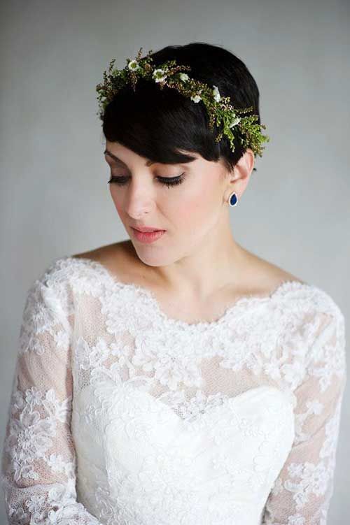 a short and volumetric black pixie with a greenery and white flower crown is amazing for a wedding