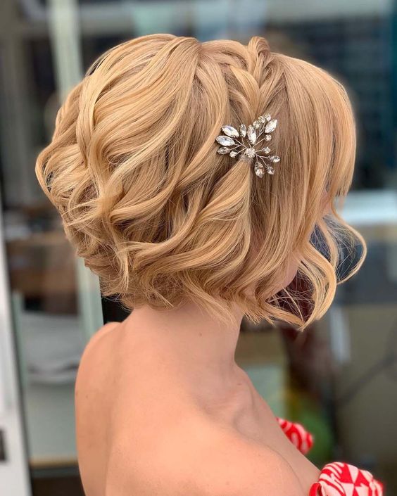 a short wavy bob accented with a braid on top the head and a single rhinestone hair piece is amazing