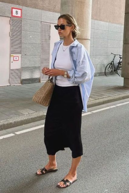a simple spring outfit with a white top, a blue button down, a black midi skirt, black sandals and a woven bag