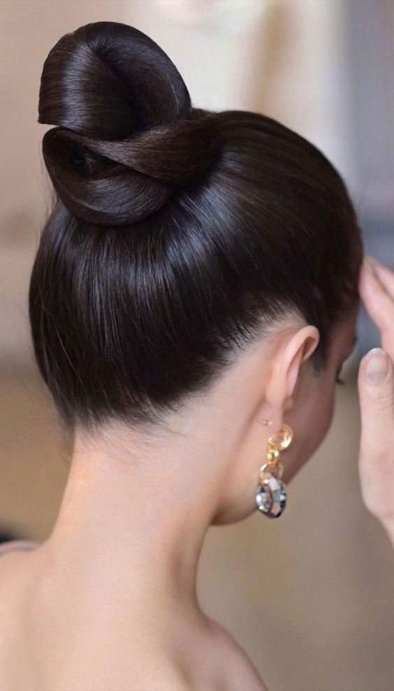 a sleek and tight top knot with a super sleek and shiny top are a gorgeous combo for a modern and exquisite bride