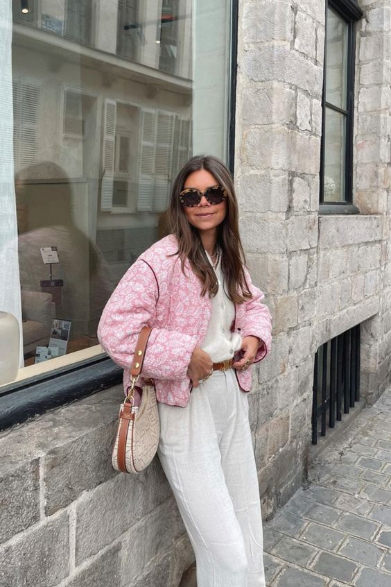 a spring outfit with a white cardigan tucked into white pants, a pink printed jacket and a printed baguette bag