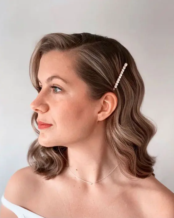 a stylish brown wavy bob with side parting and a pearl hair pin is a chic and cool wedding hairstyle to rock