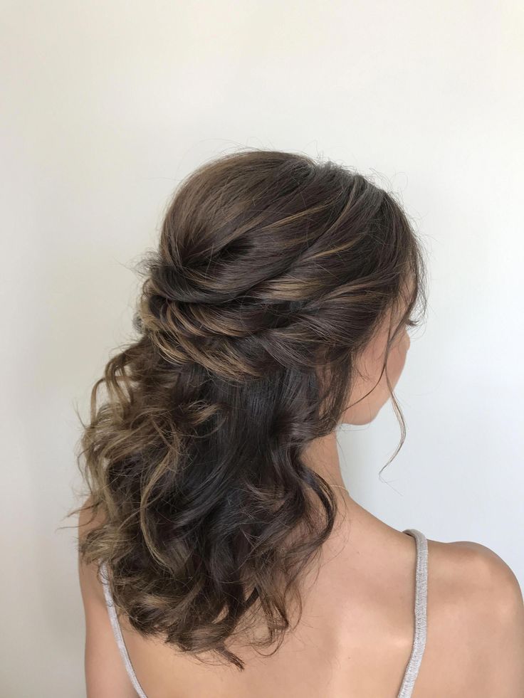 a stylish half updo with a bump on top and a triple twisted halo plus curls down looks refined and chic