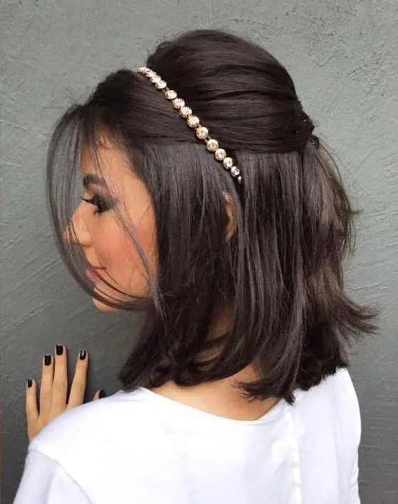 a stylish half updo with a bump on top and hair down, face-framing hair and an embellished hair piece for a party
