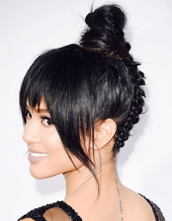 a tight top knot with a back braid and layered bangs is a cool and catchy solution for a wedding