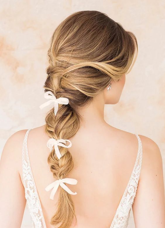 a usual and bubble braid with small bows is a trendy and very girlish solution for a wedding