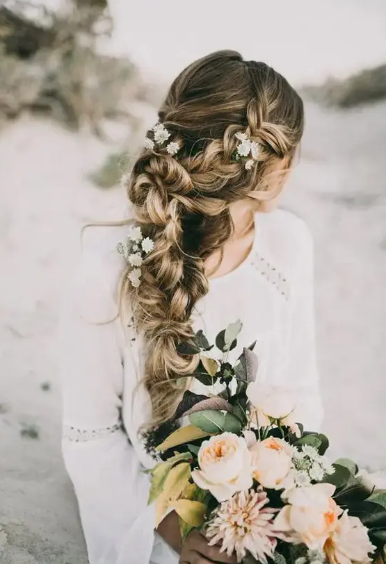 a very dimensional and textural braid made of two side ones with fresh flowers is a cool idea for a boho wedding