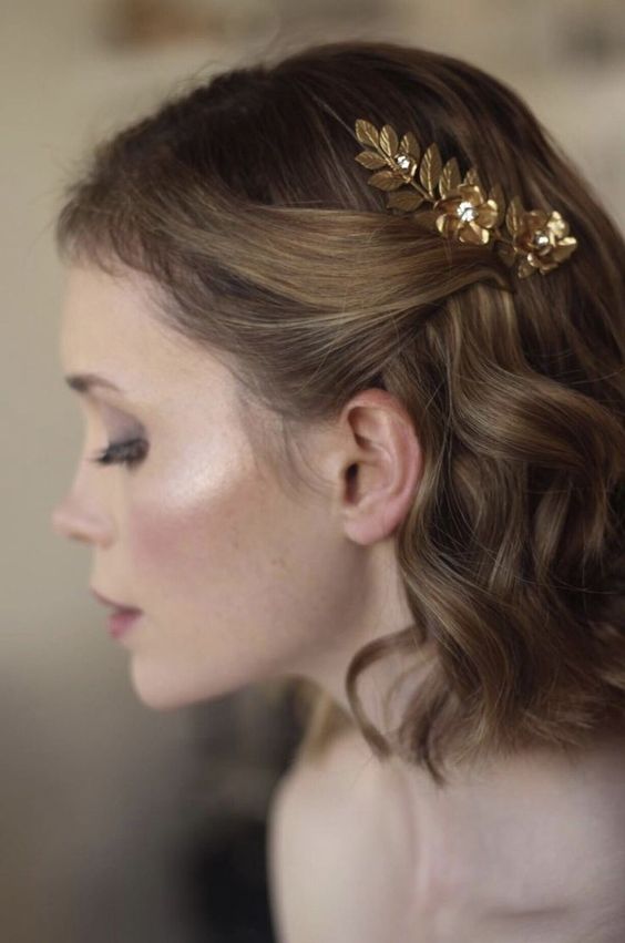a wavy bob styled as a half updo with a little gold leaf piece is a lovely and chic solution to rock