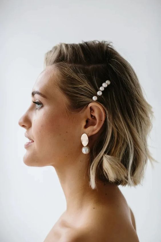 a wavy long bob with side parting and a pearl hair piece plus pearl earrings are a cool modern combo