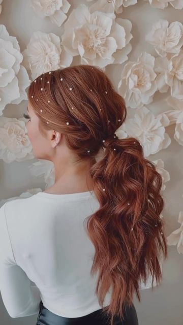 a wavy low volumetric ponytail with lots of rhinestone hairpins is a cool and catchy idea for a wedding
