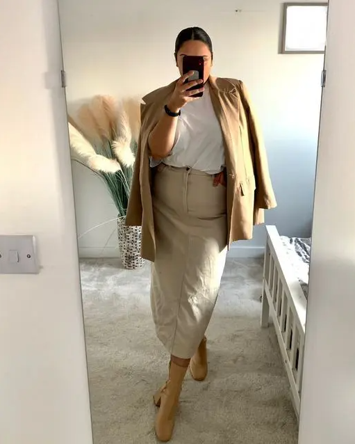 a white t-shirt, a tan denim midi, a beige oversized blazer and beige sock boots for spring