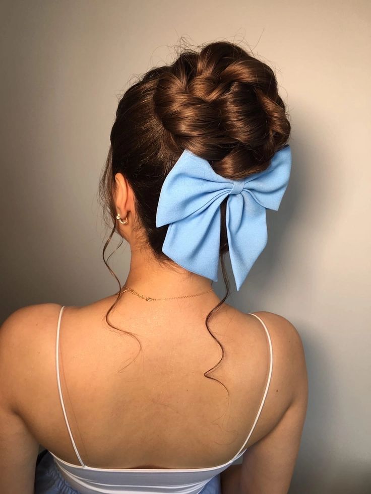 a wrapped top knot with a volumetric top, some locks down and a large blue bow to add a cute touch and some color