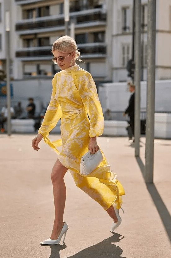 a yellow and white patterned midi dress, white heels and a white clutch for a bold yet minimal look