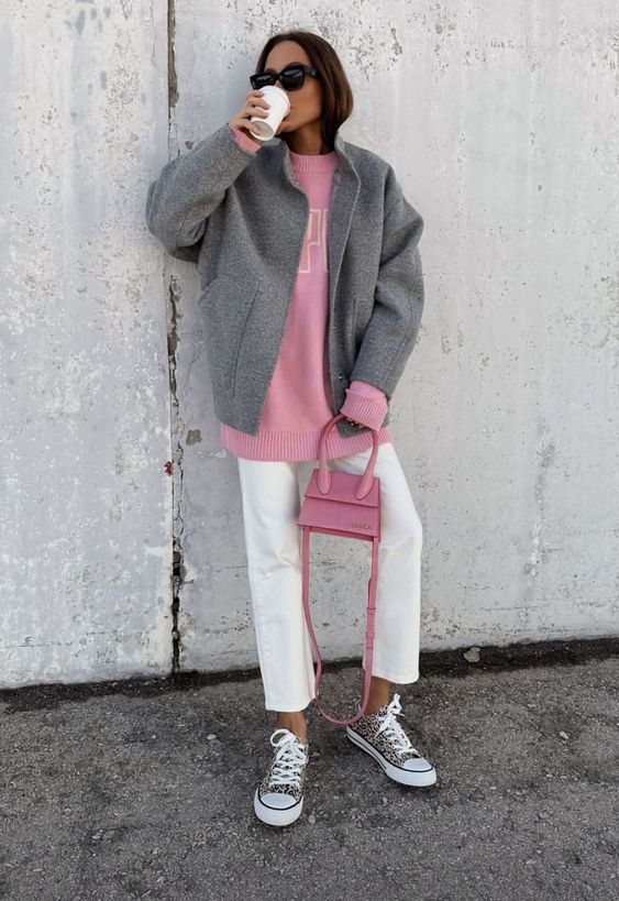 an Easter look for a cold day, with white jeans, a pink sweatshirt, a grey bomber, glitter sneakers and a pink mini bag