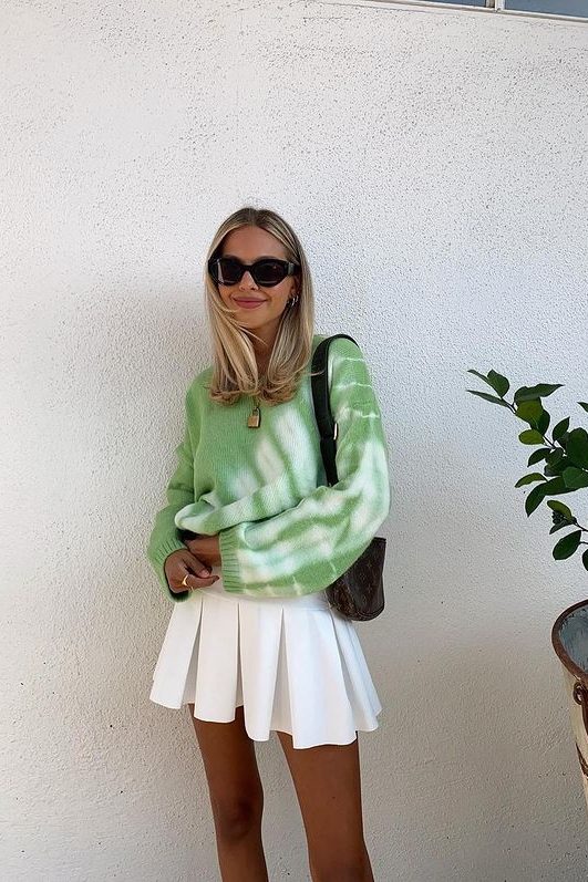 an Easter outfit with a green jumper, a white pleated mini, a printed bag is great for spring, too