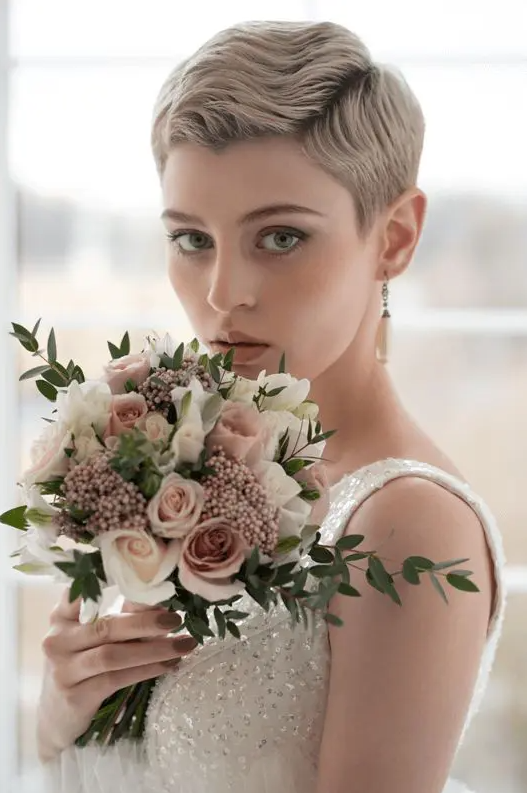 an ashy blonde wavy pixie cut with a darker root is a very chic idea with a touch of vintage and it looks cool