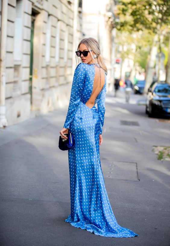 an exquisite bold blue maxi dress with polka dot print, a cutout back and a train plus a navy velvet bag and statement earrings