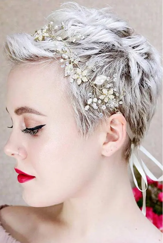 an icy blonde pixie haircut with waves and texture is accented with a rhinestone and pearl headband and looks cool
