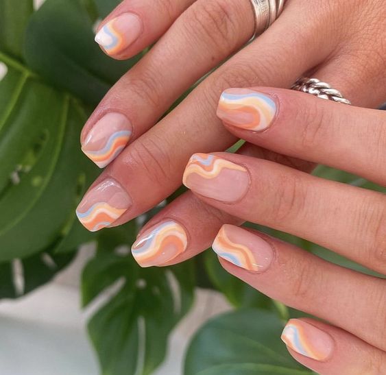 colorful summer swirl abstract nails in pastel blue, yellow and orange plus a blush backsplash is cool